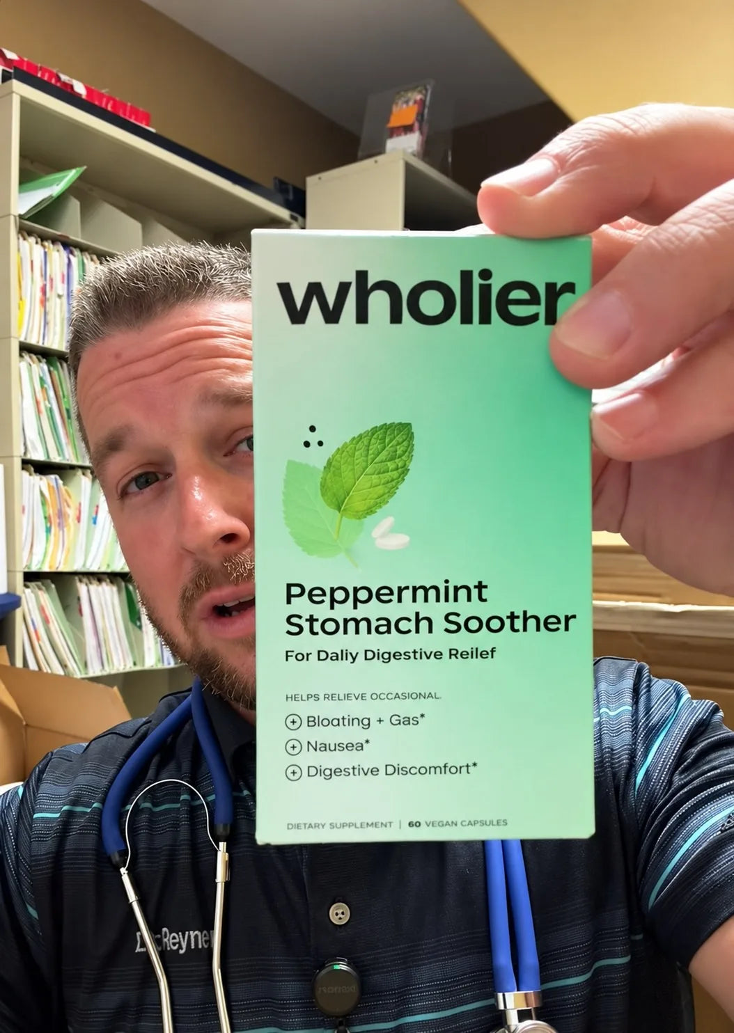 Doctor in his office holding up a box of Peppermint Stomach Soother